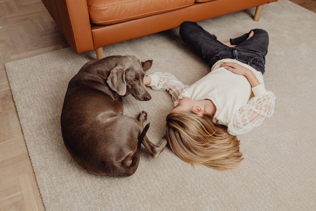 a person lying on the floor with a dog